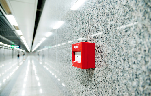 Red fire alarm on the wall of corridor.