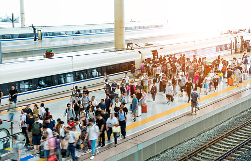 Crowd of passengers waiting on station platform.