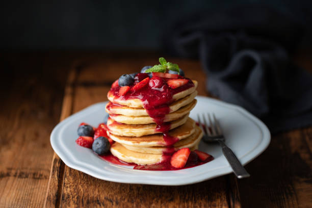tasty pancakes with berry sauce on wooden table - fruit sauce imagens e fotografias de stock