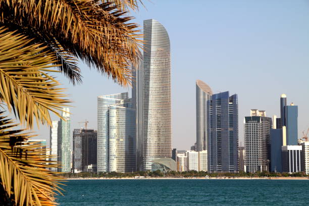 istock Abu Dhabi Skyline with water and palmtree 1093875896