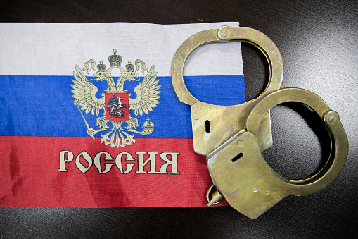 Russia flag  and police handcuffs. The concept of observance of the law in the country and protection from crime
