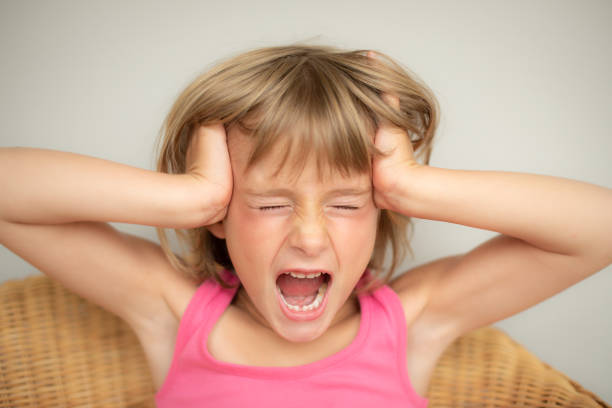 istock five year old girl holding head and screaming with open mouth 1093882500