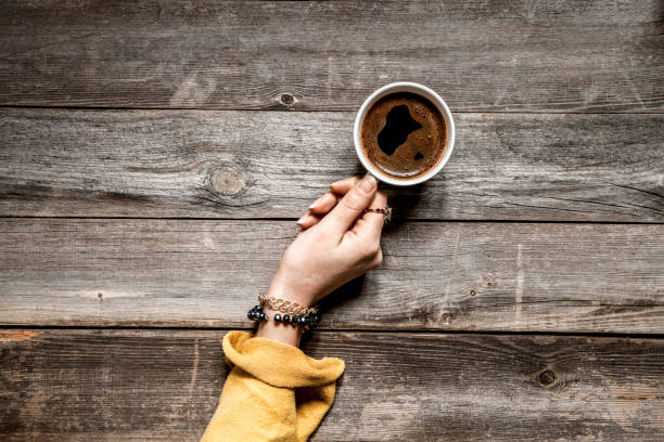 istock Woman hand drinking coffee on wooden table 1093883236