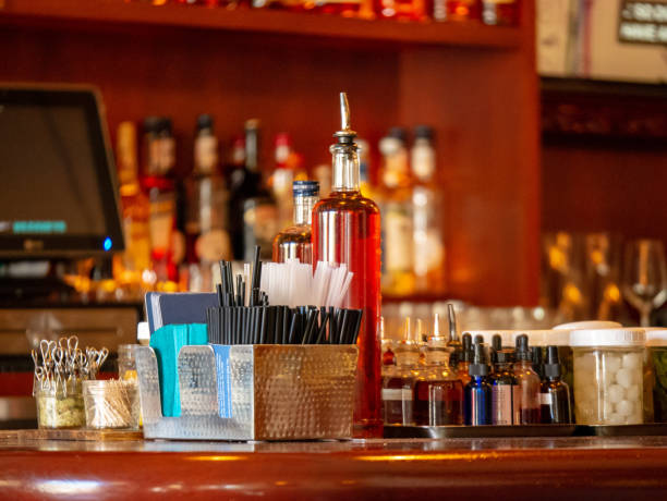 istock Straws, liquor, drinks, and various of cocktail tools sitting on bar countertop 1093883590