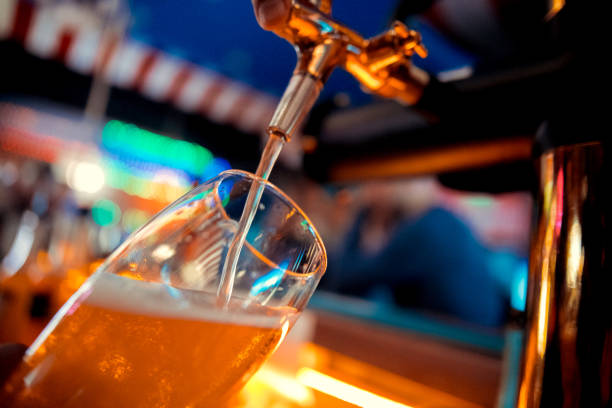bartender pours beer from the tap