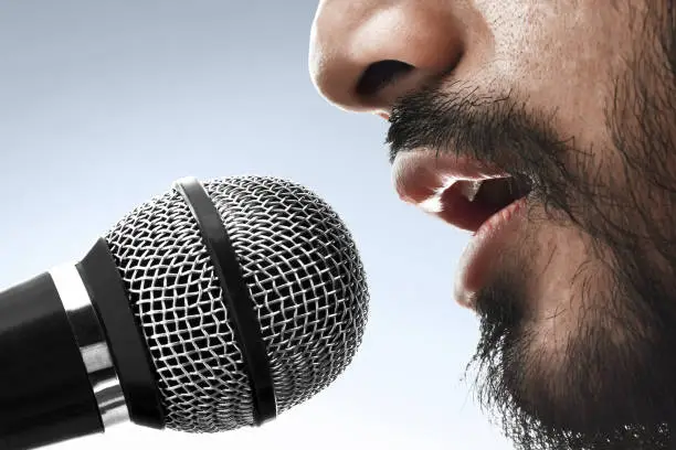 Photo of Close up singer singing with microphone