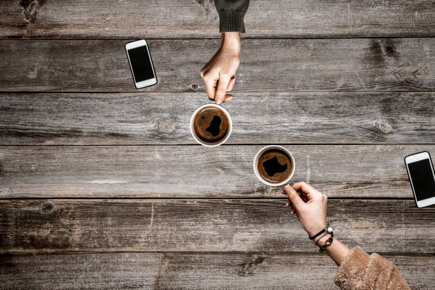 istock People hands drinking coffee on wooden table 1093893992