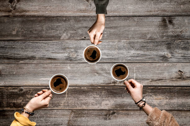 istock People hands drinking coffee on wooden table 1093894268