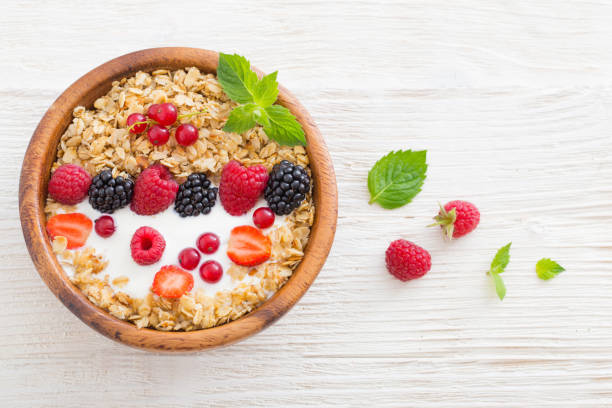 istock granola with berries on white wooden background 1093896410