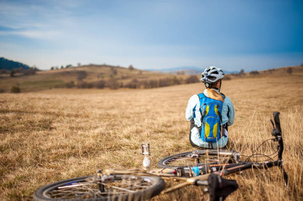 istock Female Cross-Country Cycler Taking a Break on a Meadow 1093898898