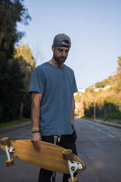 istock Man practicing with his long board on a lonely street in a sunset 1093901090