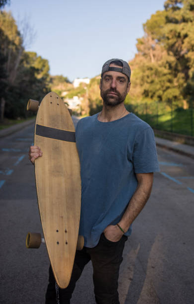 istock Man practicing with his long board on a lonely street in a sunset 1093901124