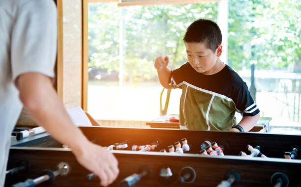 istock Father and son playing foosball in games room 1093901780