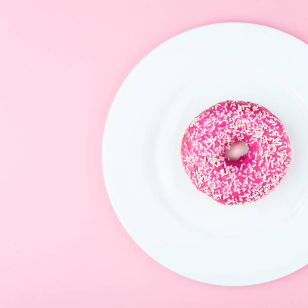 istock Pink glazed donut on pink color background 1093907124