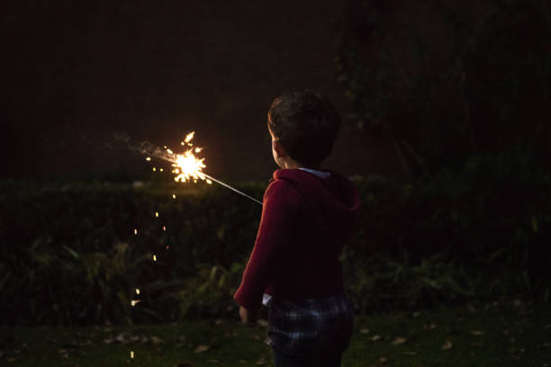 Young latin little girl outside celebrating New year's or Christmas Holidays playing with sparkles fireworks at Ecuador, Latin America.\n\nEcuador Popular Traditions at new year's eve.