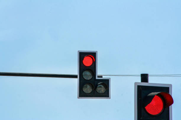 istock Two red traffic lights on clear blue sky background 1093911976