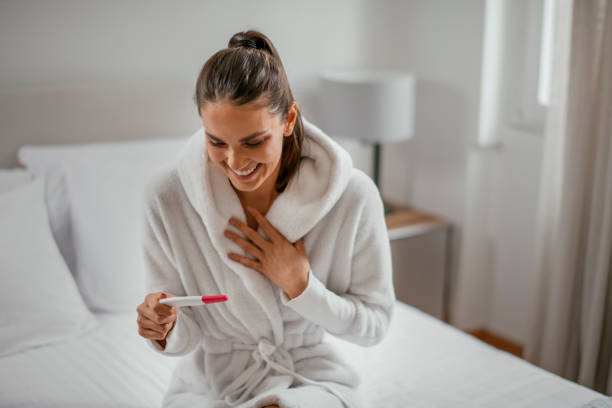 istock Young Woman Smiling at a Pregnancy Test 1093915384