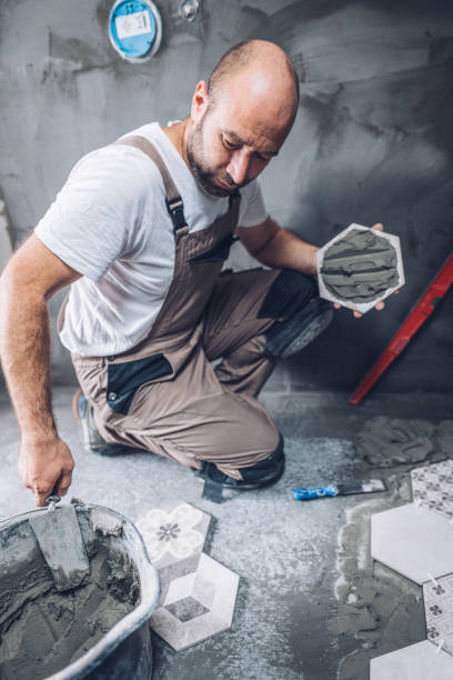 istock Mason installing tiles on the bathroom floor 1093917498