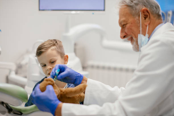 istock Child at dentists with teddy bear playing with toothbrush 1093921342
