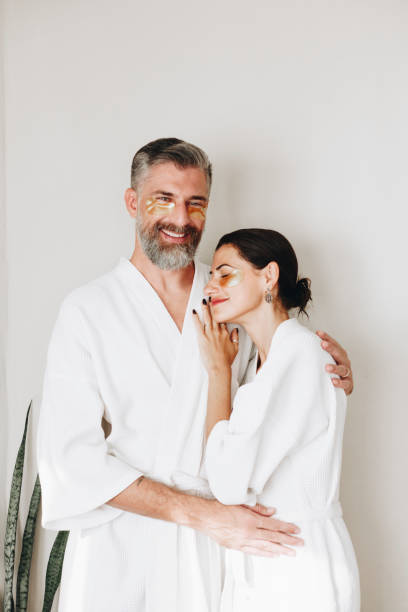 coppia rilassante con trattamento maschera occhi dorata - spa treatment health spa massaging couple foto e immagini stock