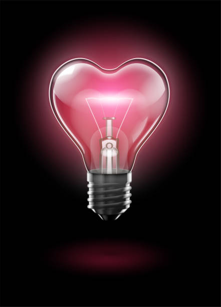 istock A transparent heart-shaped bulb against a dark background glows with a delicate pink light. Highly realistic illustration. 1093924162