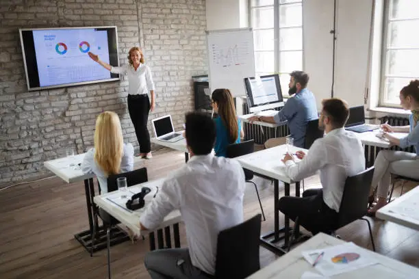 Photo of Successful happy group of people learning software engineering and business during presentation