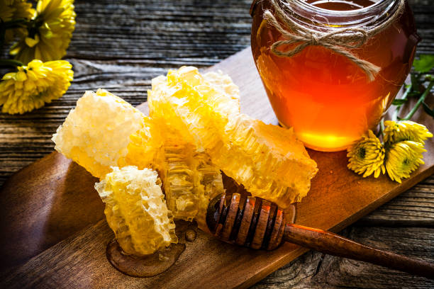 istock Honeycomb and honey jar on rustic wooden table 1093928850