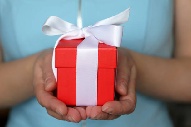 istock Red gift box in female hands close up 1093929060
