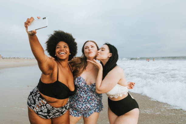 istock Beautiful curvy women taking a selfie at the beach 1093931646