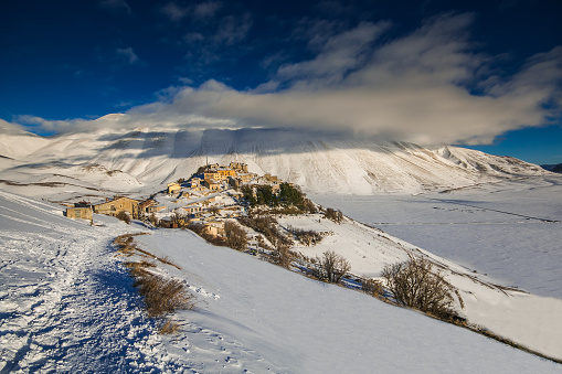 Wonderful and panoramic view of Castelluccio di Norcia village with snow in the winter season, Umbria, Italy, Europe