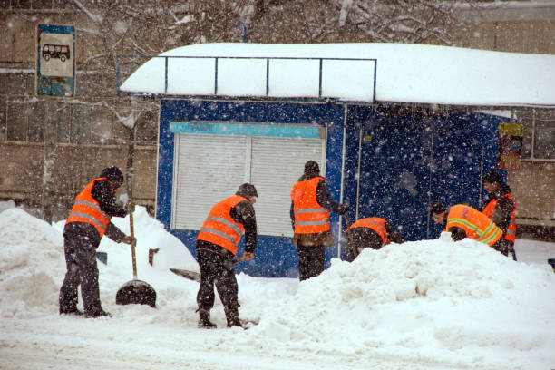 istock Workers clean the bus stop from snow during heavy snowfall in the city 1093932834