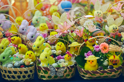 Knitted baskets filled with handmade figurines of Easter bunnies, chicks and floral ornaments on display in the gifts and crafts market.
