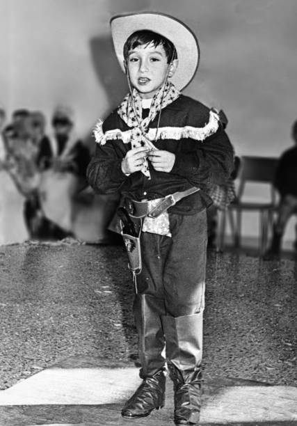 молодой мальчик маскируется под ковбойское пение в школе в 1963 году - image created 1960s фотографии стоковые фото и изображения