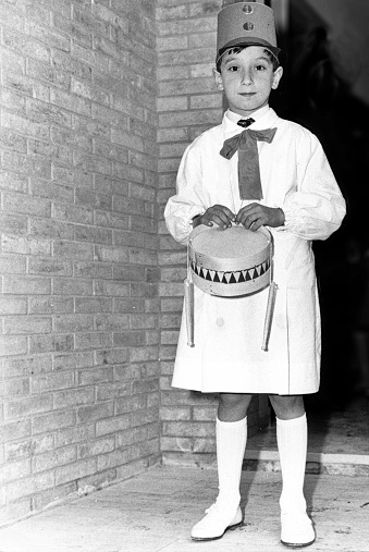 Young boy with white smock and drum in 1963