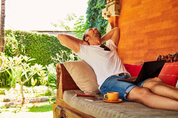 istock Man with coffee / tea and laptop on a home porch. 1093934596