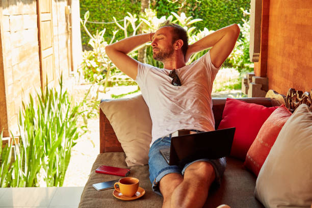 istock Man with coffee / tea and laptop on a home porch. 1093934834
