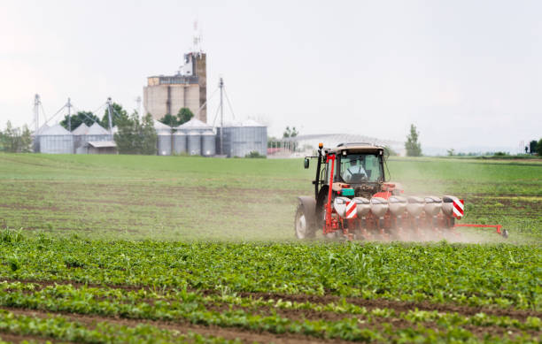 istock Farmer with tractor seeding  crops at agricultural field 1093935500