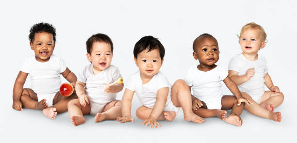 Diverse babies sitting on the floor Diverse babies sitting on the floor innocence photos stock pictures, royalty-free photos & images