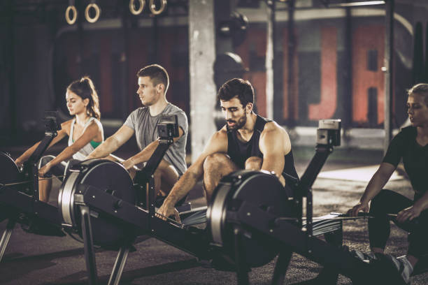 istock Group of athletes exercising on rowing machines in a gym. 1093940236