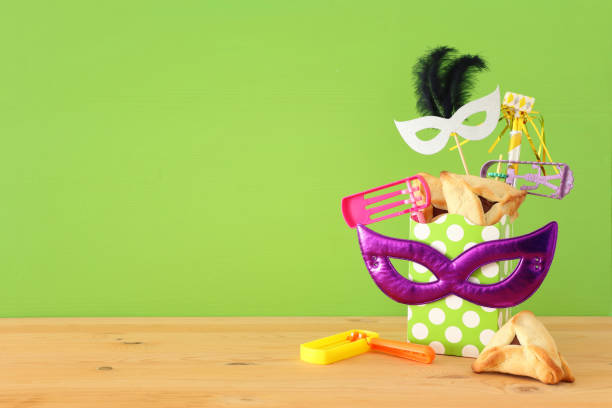 istock Purim celebration concept (jewish carnival holiday) over wooden table and green background. 1093940614