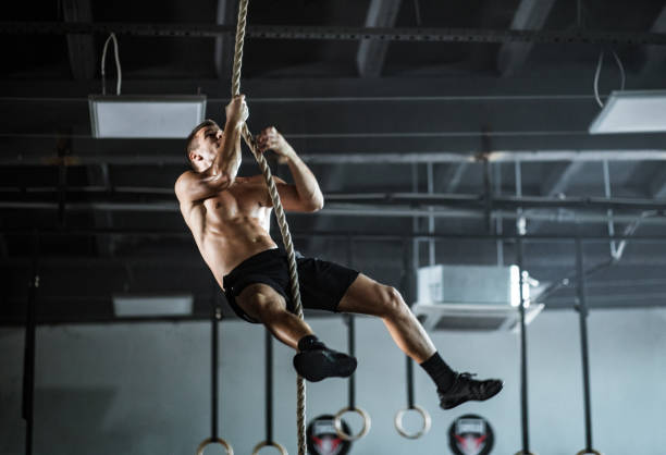 istock Young athletic man exercising strength on a rope in a gym. 1093940842