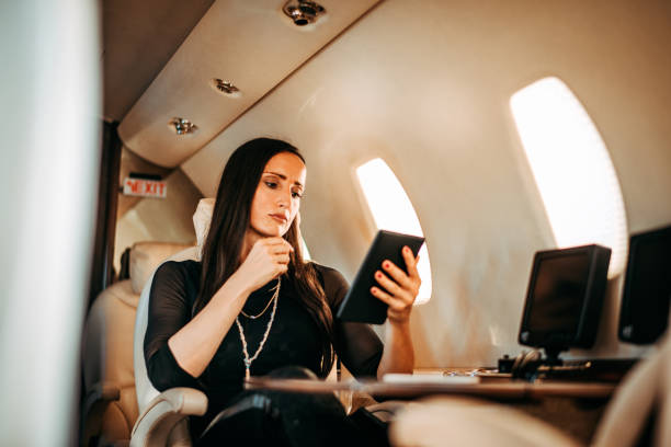 istock Rich and successful female using a digital tablet while sitting in a private airplane 1093943876