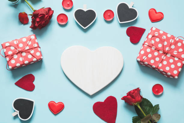 istock Valentine's card with space for text and set of giftbox, red roses on blue. Copy space. View from above. 1093946640