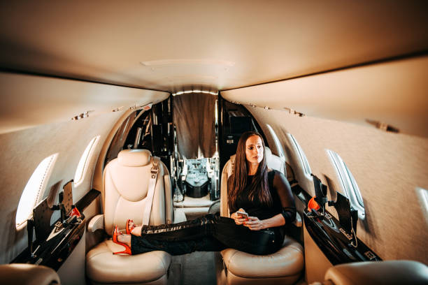 istock Successful businesswoman using her mobile phone while sitting with her feet up on a private jet 1093950570