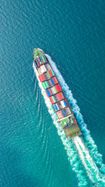 Container ship in export and import business logistics and transportation. Cargo and container box shipping to harbor by crane. Water transport International. Aerial view and top view.
