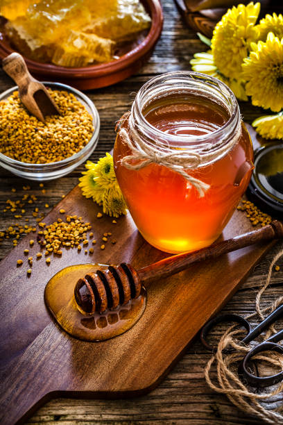 istock Honey jar, bee pollen and honeycomb on rustic wooden table 1093966700
