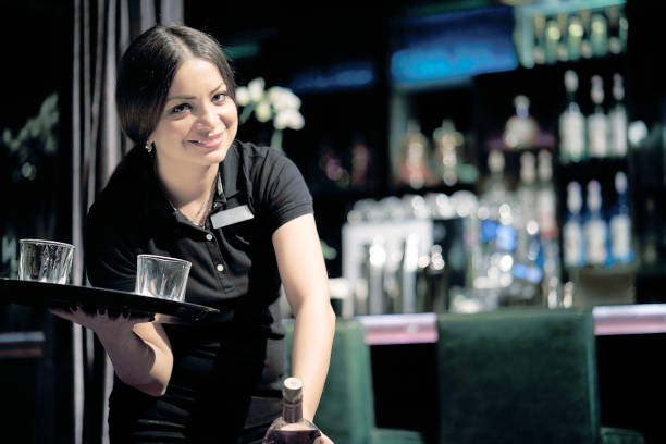 女服務員在酒吧裡給客戶送去一杯威士卡。 - 貼士 圖片 個照片及圖片檔