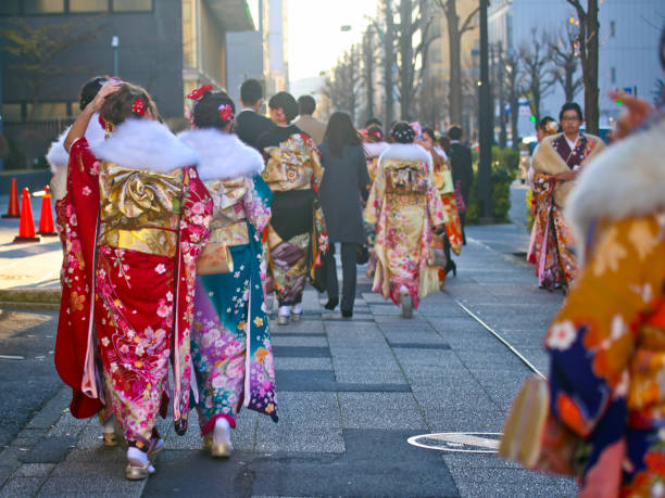 Japanese new adults wearing kimonos and suits on 'Coming of Age Day' on the street in Yokohama Yokohama, Kanagawa Prefecture, Japan - January 14, 2019: Japanese young people on the street on Coming of Age Day (Seijin No Hi 成人の日). This holday celebrate those who become twenty years of age. Most female participants wear colorful kimono. Males tend to prefer wearing business suits, though some wear traditional clothing. geta sandal photos stock pictures, royalty-free photos & images