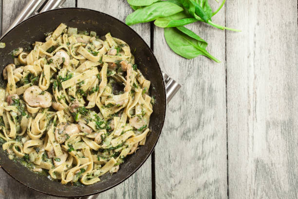 istock Tagliatelle pasta with spinach and mushrooms on a pan. 1093969496