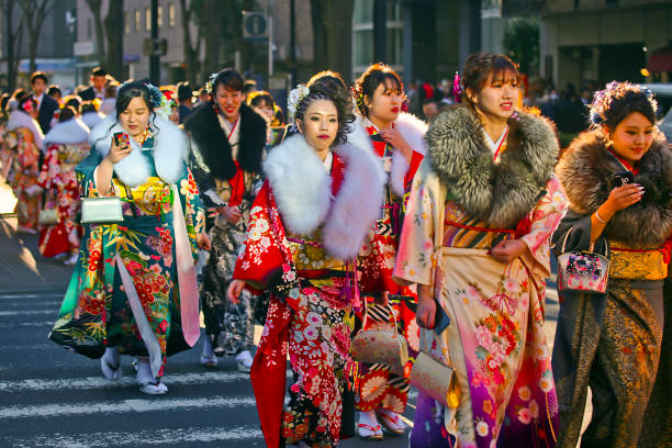 Japanese new adults wearing kimonos and suits on 'Coming of Age Day' on the street in Yokohama Yokohama, Kanagawa Prefecture, Japan - January 14, 2019: Japanese young people on the street on Coming of Age Day (Seijin No Hi 成人の日). This holday celebrate those who become twenty years of age. Most female participants wear colorful kimono. Males tend to prefer wearing business suits, though some wear traditional clothing. geta sandal photos stock pictures, royalty-free photos & images